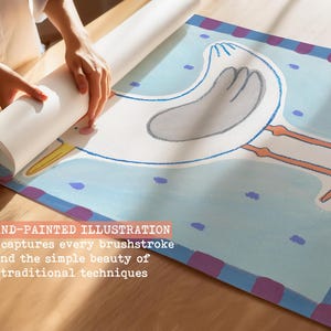 May include: A hand-painted illustration of a cartoon bird with long legs, in shades of white, gray, and orange, on a light blue background. The artwork is being unrolled. Text on the image reads: "A hand-painted illustration that captures every brushstroke and the simple beauty of traditional techniques."