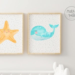 May include: Two framed watercolor prints with a white background and gray polka dots. The print on the left features a yellow starfish with a smiling face. The print on the right features a blue whale with a smiling face.