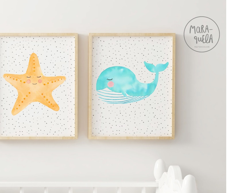 May include: Two framed watercolor prints with a white background and gray polka dots. The print on the left features a yellow starfish with a smiling face. The print on the right features a blue whale with a smiling face.