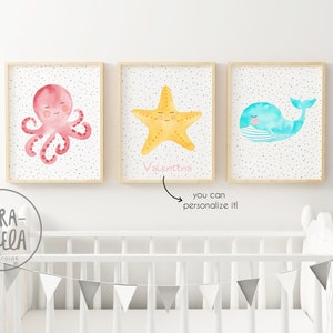 May include: Three watercolor prints featuring a pink octopus, a yellow starfish, and a blue whale. The starfish print has the name "Valentina" written below it.