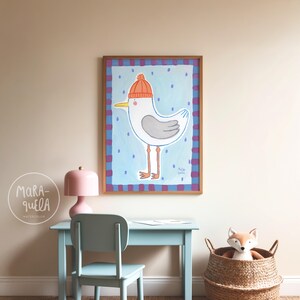 May include: A framed watercolor painting of a cartoon seagull wearing an orange knit cap. The seagull is white with gray wings and yellow beak, set against a light blue background with blue dots. The frame is brown with a blue and purple border.