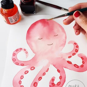 May include: A watercolor painting of a pink octopus with closed eyes and a smile. The octopus has eight tentacles with red circles on them. The painting is signed "Mara-quella Watercolor" in the bottom right corner.