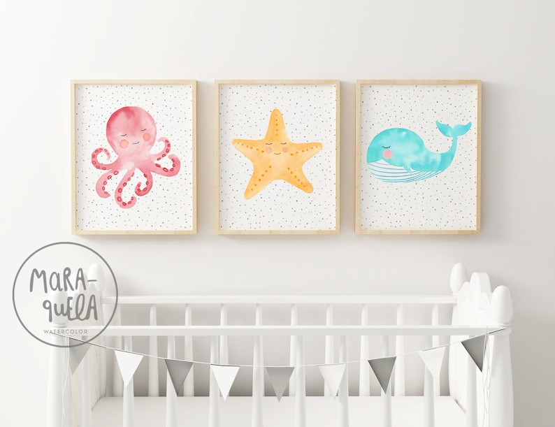 May include: Three watercolor prints featuring a pink octopus, a yellow starfish, and a blue whale. Each print has a white background with small gray dots and is framed in a light wood frame.