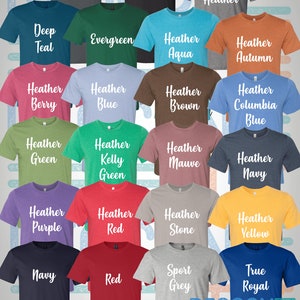 May include: A variety of t-shirt colors displayed on a white and blue striped background. The colors include: Asphalt, Black, Deep Heather, Deep Teal, Evergreen, Heather Aqua, Heather Autumn, Heather Berry, Heather Blue, Heather Brown, Heather Columbia Blue, Heather Green, Heather Kelly Green, Heather Mauve, Heather Navy, Heather Purple, Heather Red, Heather Stone, Heather Yellow, Navy, Red, Sport Grey, and True Royal.