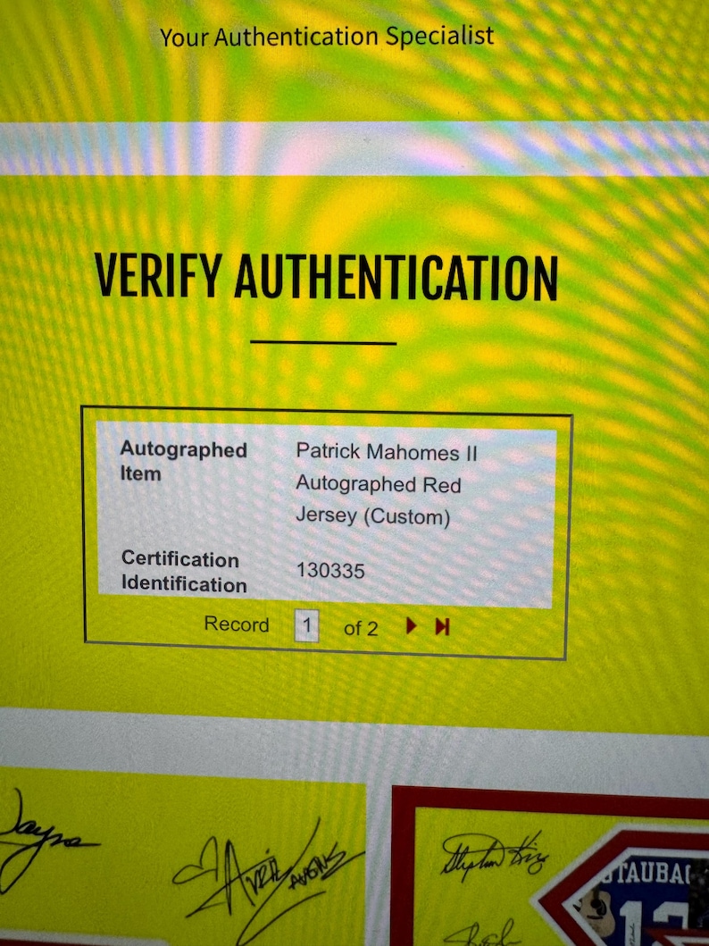 May include: A digital screen displays "VERIFY AUTHENTICATION" with details of an autographed red jersey. The item is identified as a Patrick Mahomes II autographed jersey, with certification ID 130335.