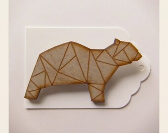 May include: A wooden geometric bear figurine in a light brown colour. The bear is made of many small triangles that create a textured surface.