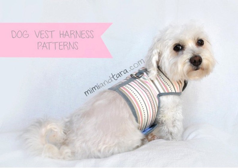 Op de afbeelding: Een witte hond draagt een gestreept vesttuig met een grijze afwerking. Het tuig heeft een metalen ring om een ​​riem aan te bevestigen. De hond zit op een wit oppervlak. De tekst "DOG VEST HARNESS PATTERNS" staat op een roze banner boven de hond. De tekst "mimiandetara.com" staat onder de hond.
