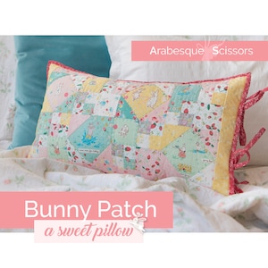 May include: A pink and yellow patchwork pillow with a bunny rabbit design. The pillow has red ties and the text "Bunny Patch a sweet pillow" is on the bottom of the image.