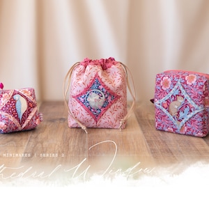 Puede incluir: Tres bolsas de tela de diferentes tamaños, todas con un patrón floral rosa y rojo con un diseño en forma de diamante en el centro. Las bolsas están hechas de una tela suave acolchada y tienen un cierre de cordón. El texto "Minimakes | Serie 2 Ventana de la Catedral" es visible en la parte inferior de la imagen.