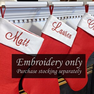 May include: Three red Christmas stockings with white cuffs, hanging from a white mantel. The stockings are personalized with the names "Matt", "Lauren", and "Owen" in red embroidery. The text "Embroidery only Purchase stocking separately" is displayed below the stockings.