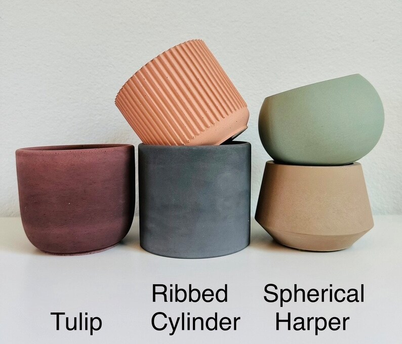 Pu&ograve; includere: Tre diversi stili di vasi in cemento. Il primo &egrave; un vaso a forma di tulipano marrone. Il secondo &egrave; un vaso cilindrico a coste grigio. Il terzo &egrave; un vaso sferico verde con una base marrone.