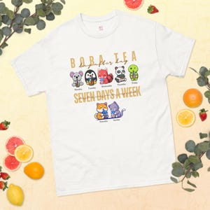 May include: White t-shirt with a graphic of cartoon animals holding boba tea. The text "BOBA tea day after day SEVEN DAYS A WEEK" is printed on the shirt.