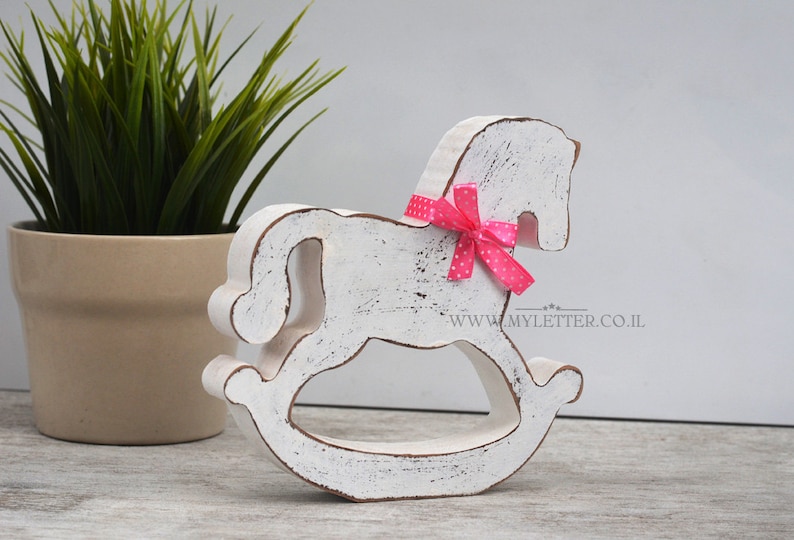 May include: White wooden rocking horse with a pink polka dot bow. The horse is distressed and has a rustic look. www.myletter.co.il