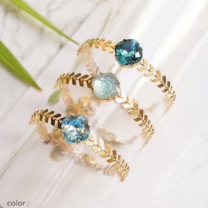 Puede incluir: Tres anillos dorados con una banda de patr&oacute;n de espiga y una piedra &uacute;nica de corte coj&iacute;n facetado. Las piedras son de color aguamarina, laguna y azul verdoso indicolita. El texto en la parte inferior dice: color: Aquamarine, Lagoon, Indicolite (teal).