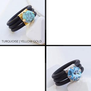 May include: Two silicone rings with a gemstone in the center. The ring on the left has a turquoise gemstone and yellow gold setting. The ring on the right has an aquamarine gemstone and a silver setting.  TURQUOISE | YELLOW GOLD and AQUAMARINE | SILVER are written below the rings.