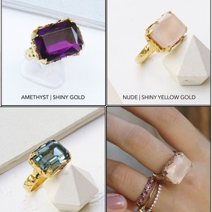 May include: Four rings with different gemstones and metal finishes. The top left ring features a purple amethyst stone with a shiny gold band. The top right ring features a nude opaque stone with a shiny yellow gold band. The bottom left ring features a blue Indian sapphire stone with a shiny yellow gold band. The bottom right ring features a nude opaque stone with a rose gold band.