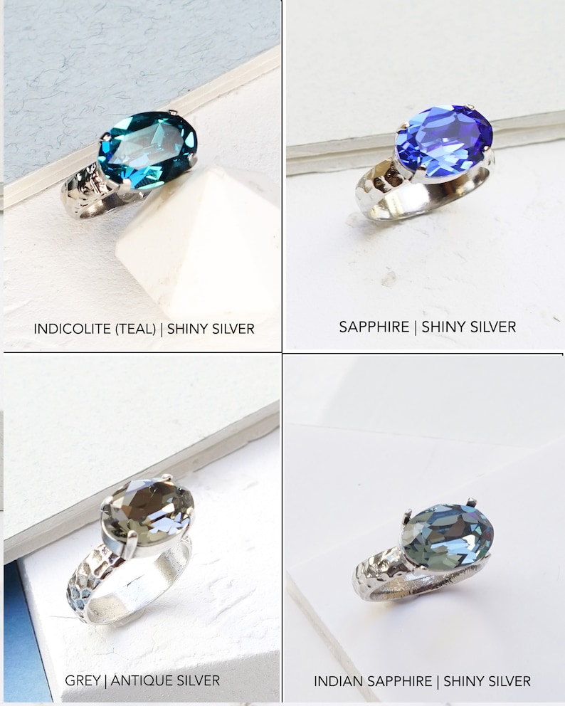 May include: Four rings with oval-cut faceted stones in teal, blue, grey, and light blue. Each ring features a textured, hammered-style metal band. The text labels indicate the colors as Indicolite, Sapphire, Grey, and Indian Sapphire with silver finishes.
