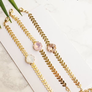 Puede incluir: Tres pulseras de tono dorado con un dise&ntilde;o de cadena de espiga y una piedra facetada individual. Las piedras est&aacute;n disponibles en colores &oacute;palo blanco, &oacute;palo rosa y rosa vintage. Cada pulsera incluye un cierre de mosquet&oacute;n y una cadena extensora.