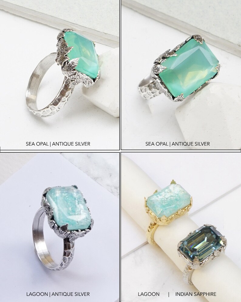 May include: Four silver rings with different gemstones. The top left ring features a sea opal gemstone with a leafy design. The top right ring features a sea opal gemstone with a leafy design. The bottom left ring features a lagoon gemstone with a leafy design. The bottom right ring features an Indian sapphire gemstone with a leafy design.