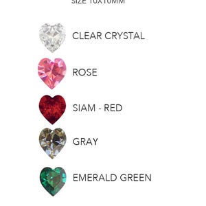 May include: Hely Designs 10x10mm heart-shaped crystals in five colors: clear, rose, siam red, gray, and emerald green. Each crystal is faceted and arranged vertically with its corresponding color name printed in black text to the right side.
