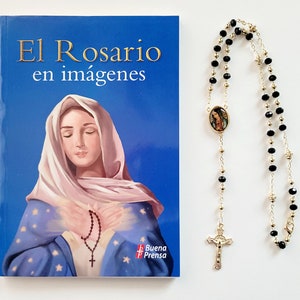 May include: A book titled "El Rosario en imágenes" featuring an illustration of the Virgin Mary on the cover. A black and gold rosary with a small image of the Virgin Mary is also pictured.
