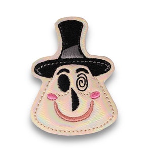 May include: Embroidered patch featuring a whimsical face with a top hat. The design includes a black top hat, a smiling face with a spiral eye, and pink cheeks. The patch has a pearlescent background and a stitched border.