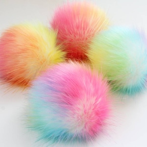 May include: Five fluffy pom poms in a rainbow of colors. The pom poms are made of soft, colorful fur and are perfect for adding a touch of whimsy to any project.