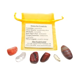 May include: A yellow pouch with a white label that reads "Stones for Creativity" and lists different types of stones and their associated properties. The pouch contains six small, polished stones in various colors and patterns.