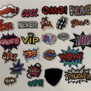 May include: A collection of colorful iron-on patches with various words and phrases, including "OOPS!" "COOL" "OMG!" "PEACE" "LOVE" "NEVER" "OH YEAH" "#" "YES!" "GREAT!!" "VIP" "YAY!" "COOL" "LOL!" "STAR" "POW!" "POW!" "WOW!" "POP!" "WOW!" "OOPS!" "BOOM" "PHWOAR!!"