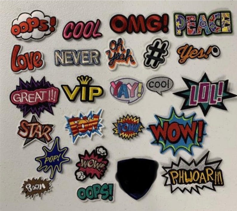May include: A collection of colorful iron-on patches with various words and phrases, including "OOPS!" "COOL" "OMG!" "PEACE" "LOVE" "NEVER" "OH YEAH" "#" "YES!" "GREAT!!" "VIP" "YAY!" "COOL" "LOL!" "STAR" "POW!" "POW!" "WOW!" "POP!" "WOW!" "OOPS!" "BOOM" "PHWOAR!!"