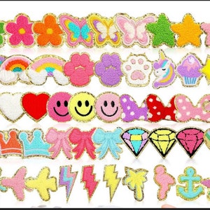 May include: A collection of colorful felt patches with various designs, including hearts, stars, rainbows, butterflies, crowns, and more. The patches are outlined in gold glitter.