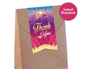 Peut inclure: Un sac cadeau en papier brun avec une étiquette de remerciement colorée représentant une lampe à genie, un tapis volant et une ville dorée. L'étiquette a un motif mandala violet, rose et bleu avec des accents dorés. Le texte sur l'étiquette dit "Merci".