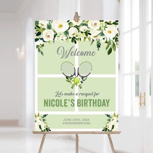 Pu&ograve; includere: Un cartello di benvenuto per una festa di compleanno a tema tennis. Il cartello presenta uno sfondo verde chiaro, decorazioni floreali bianche e la parola "Benvenuto". Include racchette da tennis, una palla e il testo "Let's make a racquet for NICOLE'S BIRTHDAY."