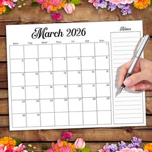 Puede incluir: Un calendario blanco de marzo de 2026 con un borde floral. El calendario tiene un diseño de cuadrícula con fechas y días de la semana. La palabra "Notas" está en la parte superior derecha. Una mano sostiene un bolígrafo sobre el calendario.