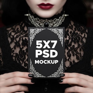 May include: A black 5x7 PSD mockup card with white text and ornate corner designs. The card is held against a black lace background. The image has a gothic aesthetic.