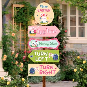 Puede incluir: Un conjunto de cinco carteles con temática de Pascua con ilustraciones de conejos y flechas. Los carteles dicen "Feliz Pascua", "Búsqueda de huevos", "Sendero de conejos", "Girar a la izquierda" y "Girar a la derecha".