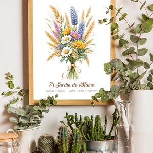 May include: A framed print with a watercolor illustration of a floral bouquet, including wheat, daisies, and lavender. The text "El Jardin de Mama" is displayed, with names below. The print is in a wooden frame, surrounded by plants.