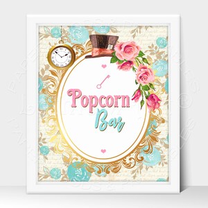 May include: A printable sign for a popcorn bar with a whimsical Alice in Wonderland theme. The sign features a gold ornate frame with a pink and blue text overlay that reads "Popcorn Bar". The background features a vintage floral pattern with a pocket watch and a Mad Hatter's hat.