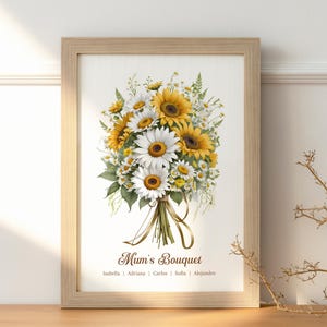 May include: A framed print featuring a watercolor bouquet of sunflowers and daisies. The flowers are tied with a ribbon. The text "Mum's Bouquet" is below the flowers, with names beneath it. The frame is light brown.