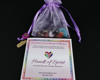May include: A purple drawstring bag filled with seven colorful gemstones. The bag is labeled "Gemstone Enrichment Collection" and is part of the "Hands of Spirit" brand. The text on the card reads "Pouches containing 7 stones, meticulously researched, to assist you in specific areas of healing and self advancement."