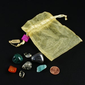 May include: A yellow organza bag with a pink tag that says "Draw Your Power" and a collection of eight tumbled stones, including green, blue, brown, clear, and gold.