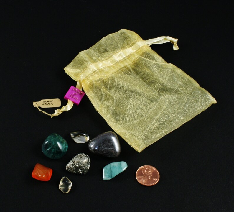 May include: A yellow organza bag with a pink tag that says "Draw Your Power" and a collection of eight tumbled stones, including green, blue, brown, clear, and gold.