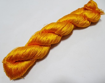 May include: A skein of bright yellow silk yarn, tightly twisted and ready for crafting. The yarn has a lustrous sheen, reflecting light and showcasing its vibrant color. Ideal for knitting, crochet, or embroidery projects.