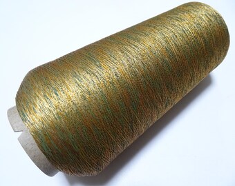May include: A spool of gold and green metallic thread. The thread is wound around a cardboard spool with a paper label.