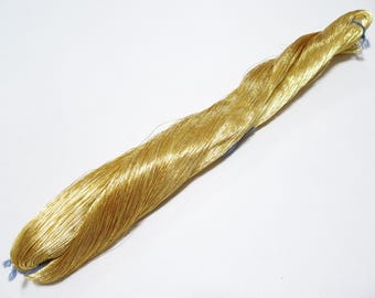 May include: A spool of gold metallic thread.