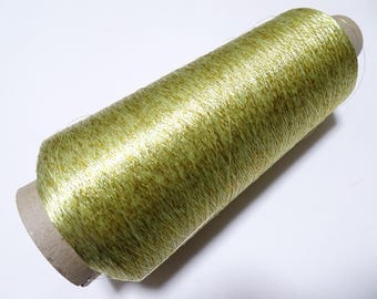 May include: A spool of green metallic thread with a brown paper label.