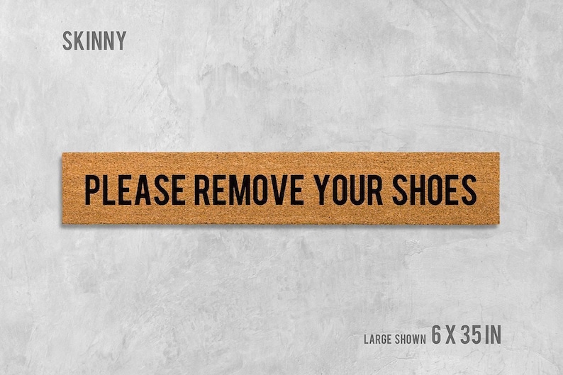 a rectangular sign with the text "PLEASE REMOVE YOUR SHOES" written on it.