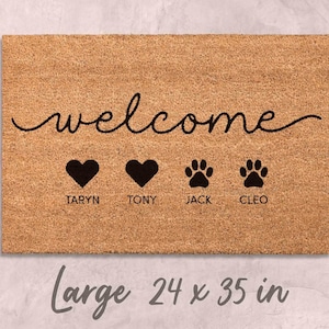 A welcome mat with the word "welcome" written on it, along with three heart symbols and the names "TARYN", "TONY", and "JACK" below them.
