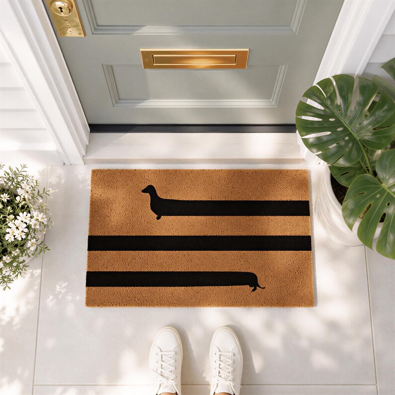 a pair of white sneakers standing on a white tiled floor, with a door and a plant nearby. The door has a gold mail slot, and there is a decorative mat with a black and orange design on the floor.