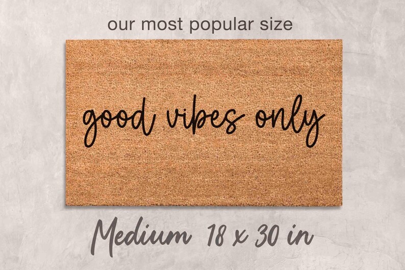 A medium-sized rectangular welcome mat with the text "good vibes only" printed on it.